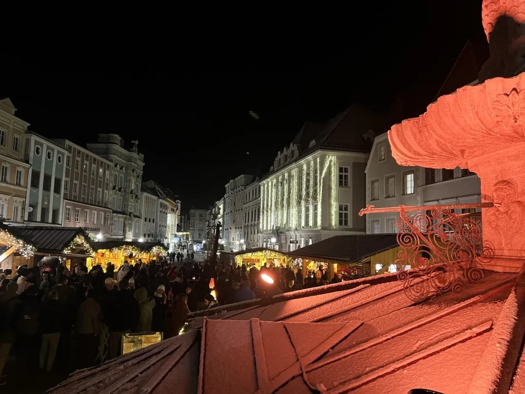 Verschneiter Leopoldibrunnen mit Blick über das Adventdorf am Abend