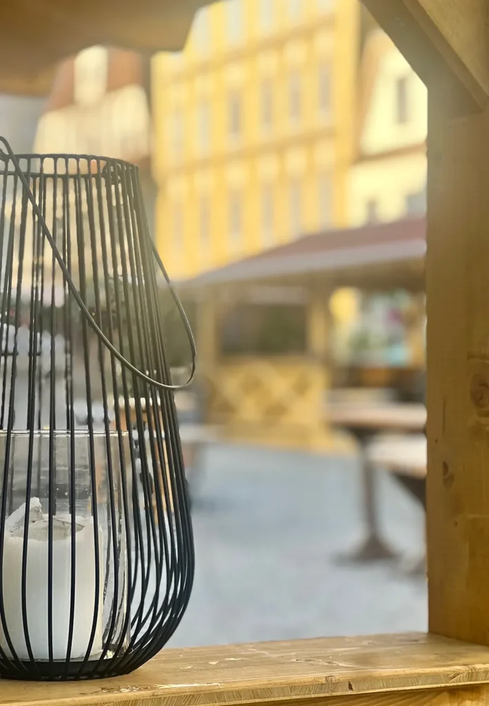 Windlicht an einer Hütte, im Hintergrund der Stadtplatz